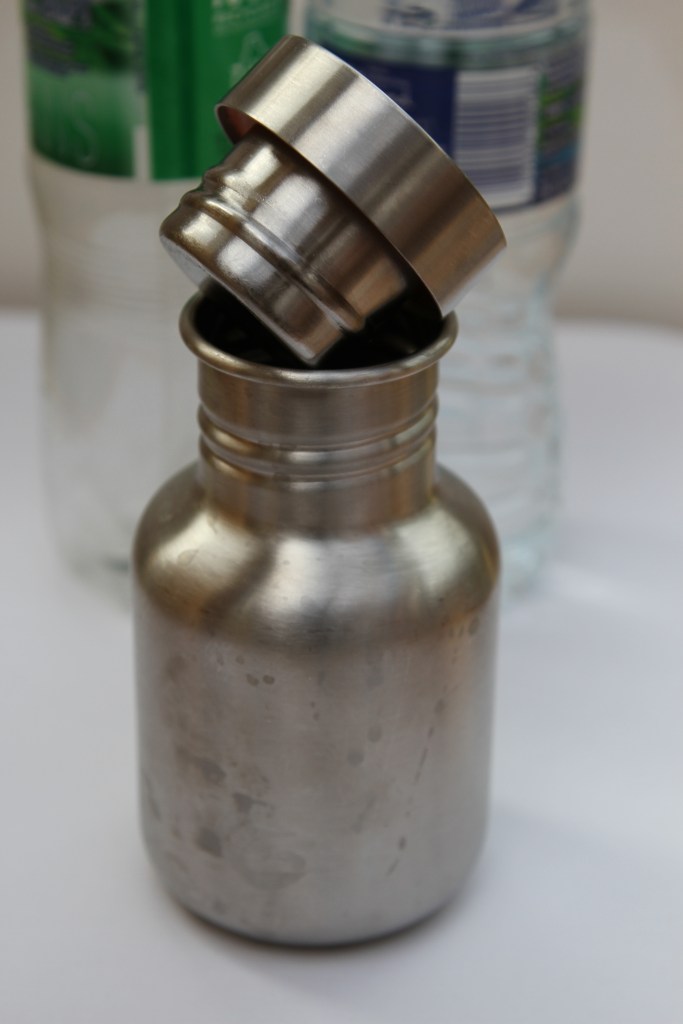 Refillable water bottle with plastic bottles in the background