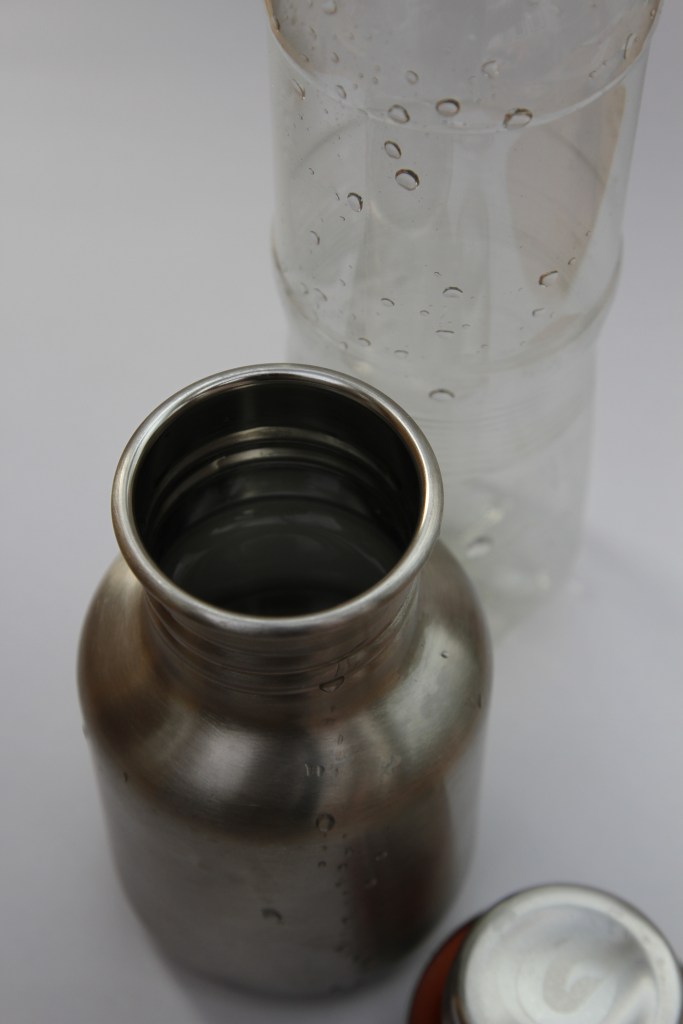 Stainless steel water bottle and plastic bottle behind